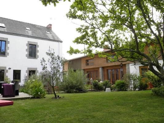 a house with a green yard next to a building at La Maison Bizienne Guérande in Guérande