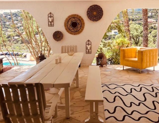 a living room with a wooden table and a yellow chair at Villa Hirondelles 35 in Cavalaire-sur-Mer