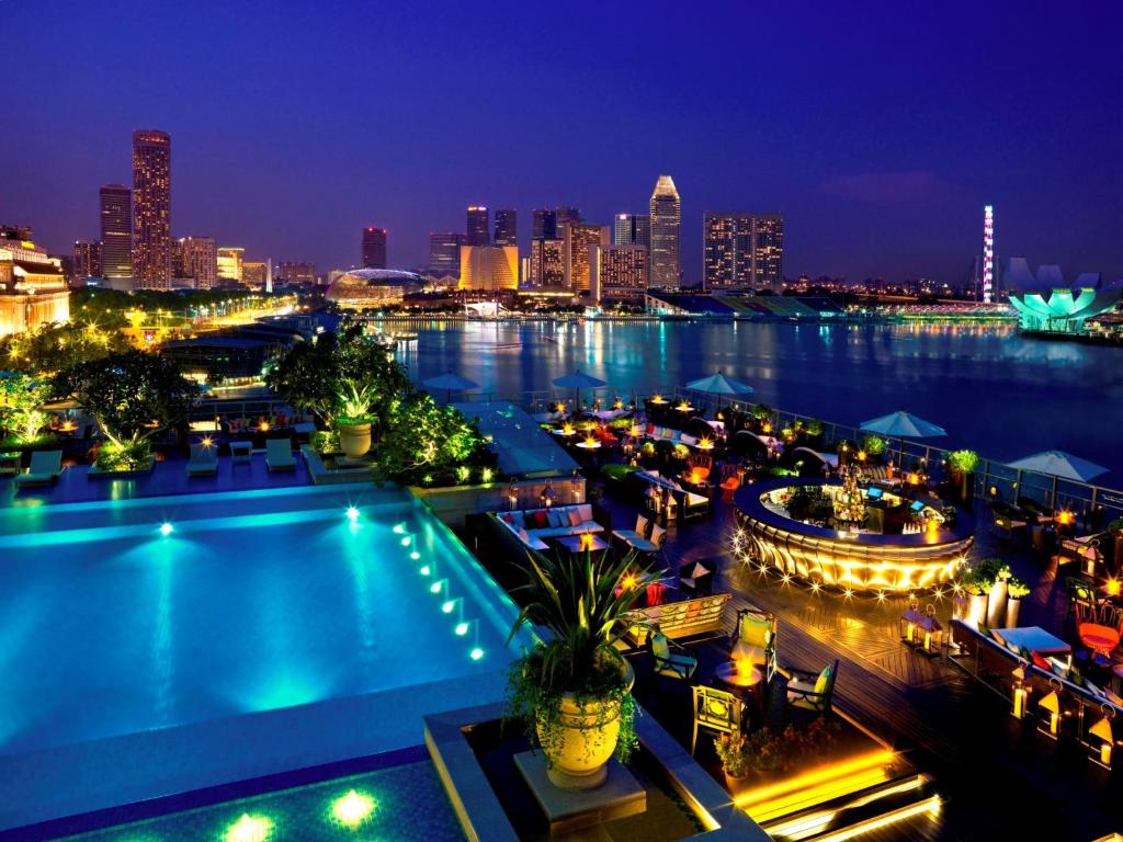 a city skyline at night with a swimming pool at The Fullerton Bay Hotel Singapore in Singapore