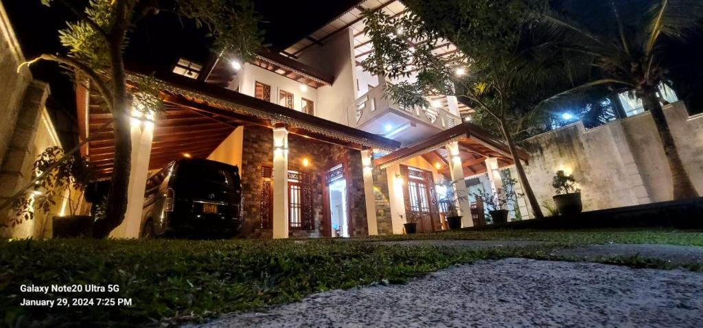 una casa iluminada por la noche con luces en CAW Dream Villa, en Ahangama