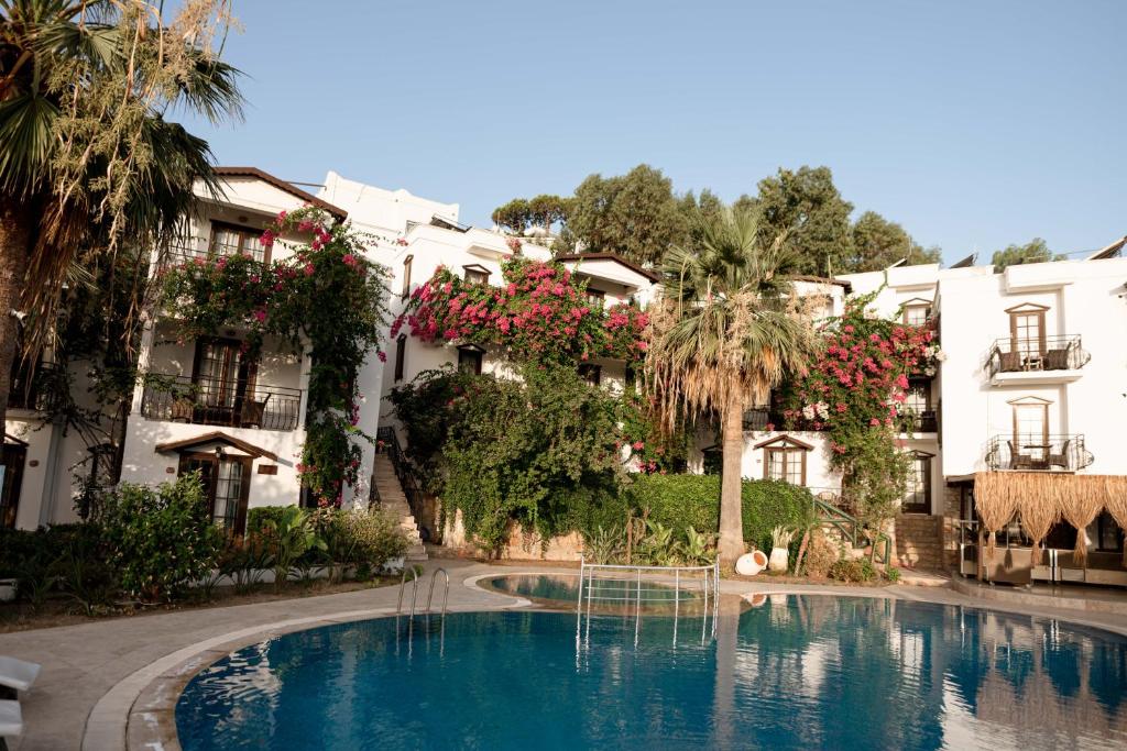 a hotel with a swimming pool in front of a building at Mare Garden Hotel in Akyarlar