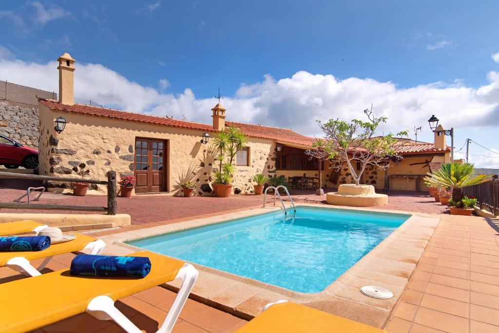 una casa con piscina frente a una casa en Casa Rural Tinamar, en Vega de San Mateo