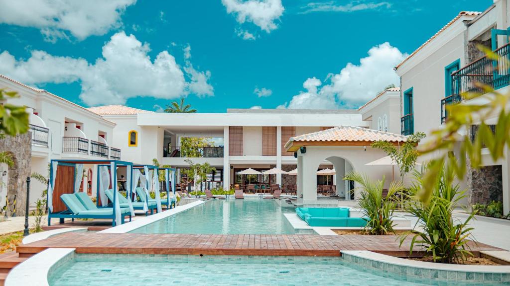 una piscina en un complejo con sillas azules en Resende Imperial Hotel & Spa, en Itacaré