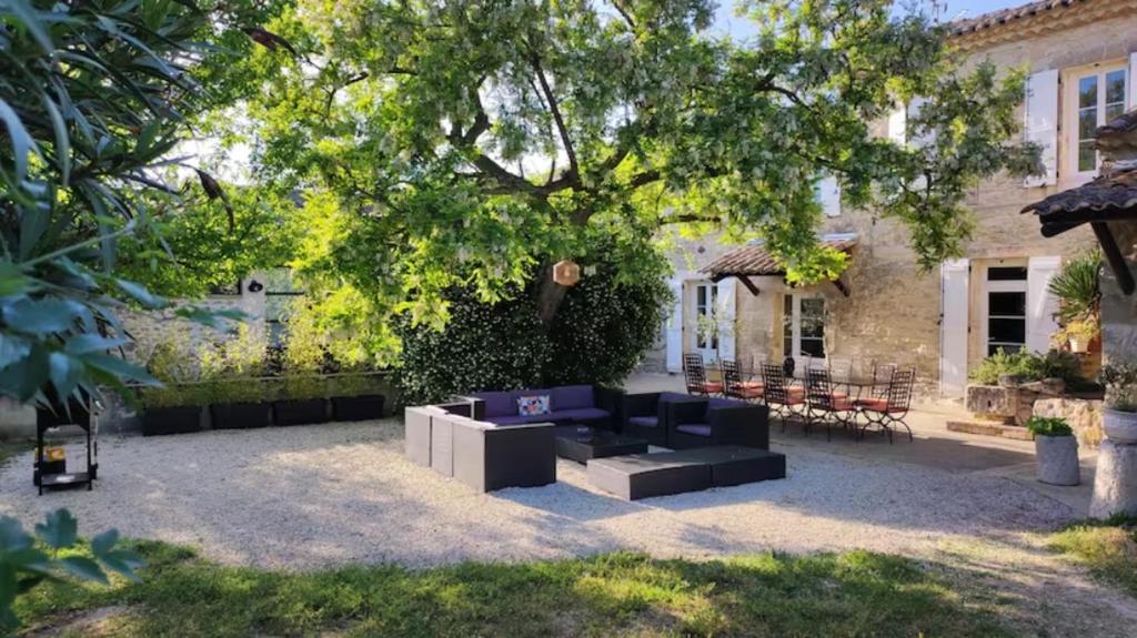 a patio with a black couch in front of a house at A la Maison d'Hôtes in La Baume-de-Transit