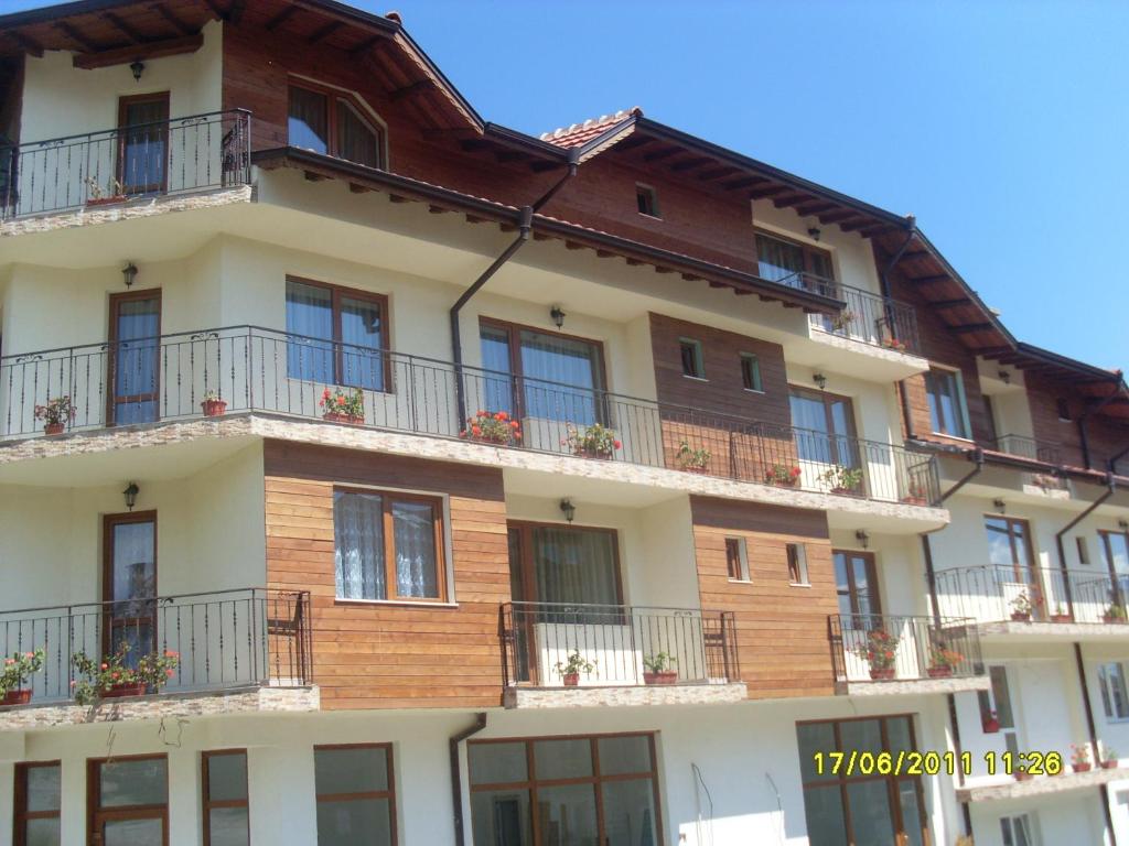 a tall building with balconies and windows on it at Hotel Gazei in Bansko