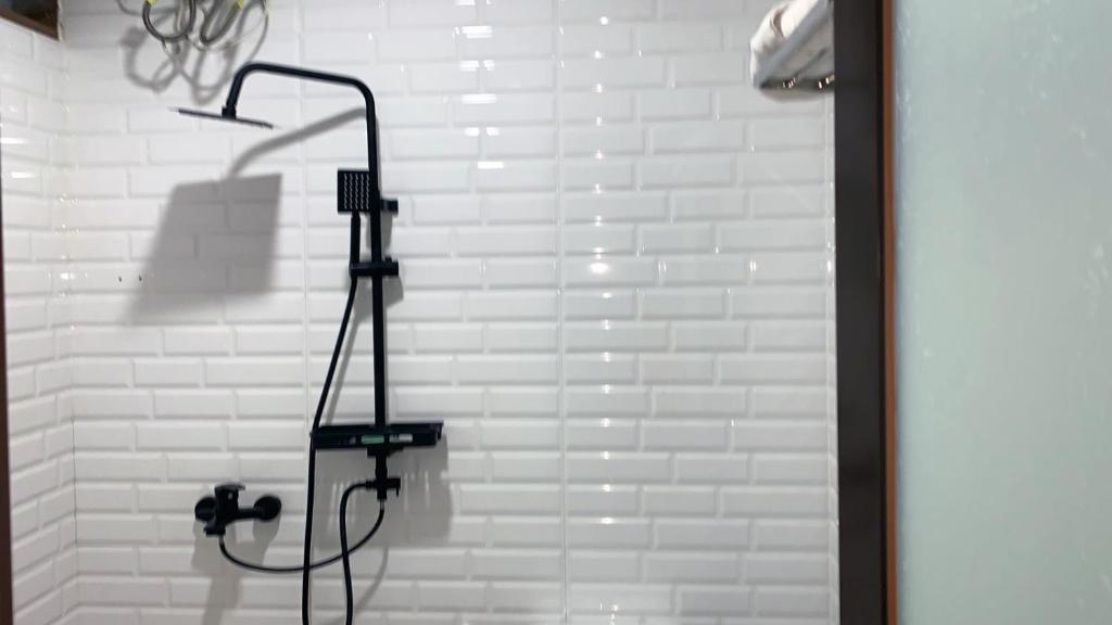 un bagno con doccia e parete di mattoni bianchi di tekMIRA Hotel a Bandung