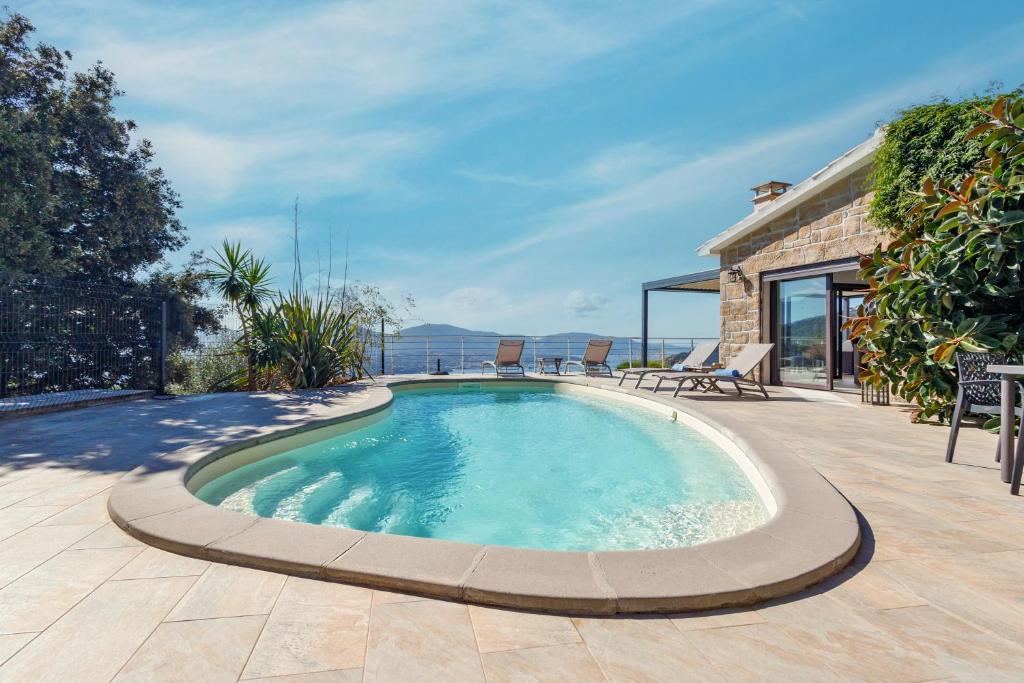 - une piscine sur une terrasse avec une maison dans l'établissement Villa Bumortu, à Olmeto