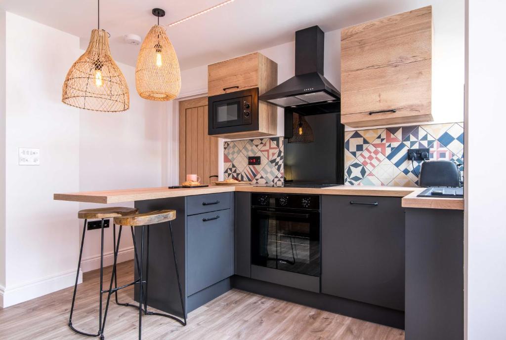 a kitchen with black appliances and wooden cabinets at Railway Apartments Rugby in Rugby