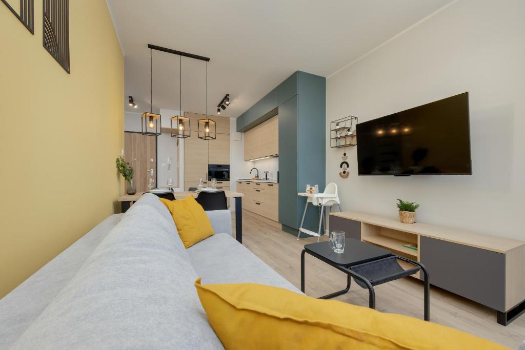 - un salon avec un grand canapé et un bureau dans l'établissement Unique Szczesliwa Apartment with Balcony Parking and AC by Renters, à Gdańsk