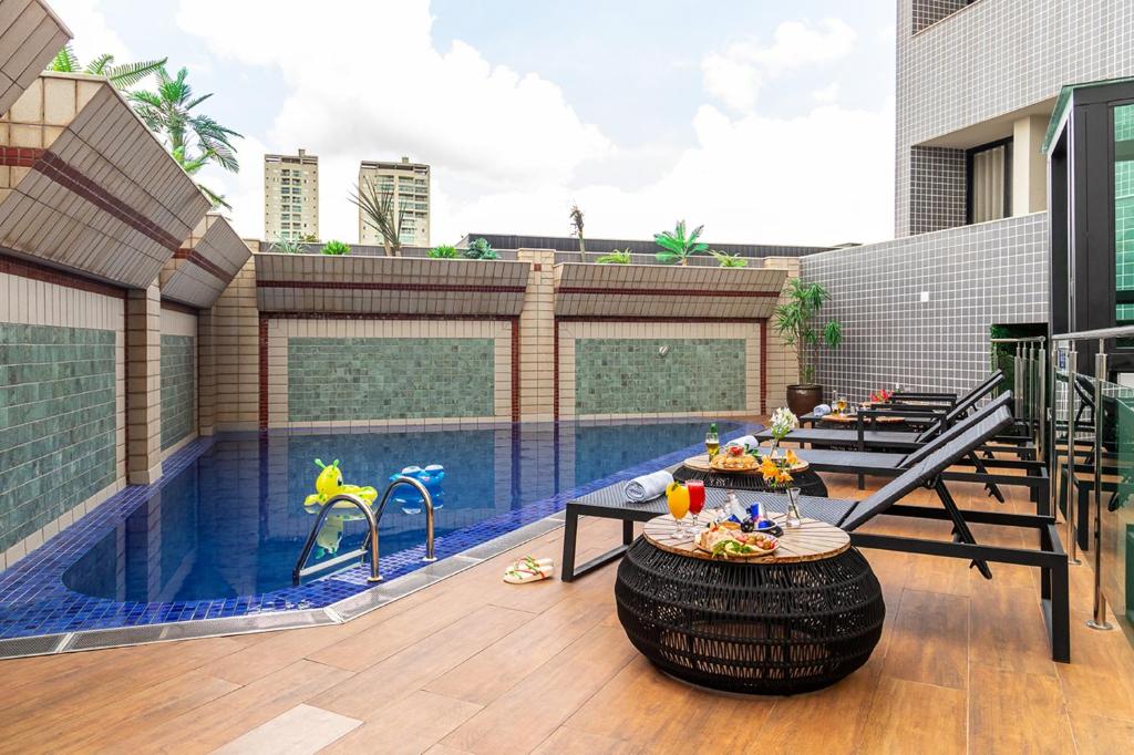 un patio con piscina con mesa y piscina en Hotel Dan Inn Uberlandia, en Uberlândia