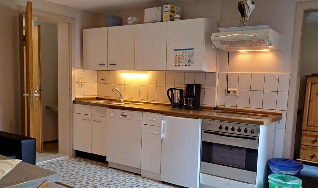 a kitchen with white cabinets and a stove top oven at Ferienhof Jens Ferienwohnung 8 "Kronsgaard" in Kronsgaard