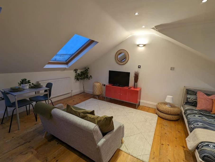 uma sala de estar com um sofá e uma mesa em Fabulous Studio Retreat - Flat 4 Highbury em Londres