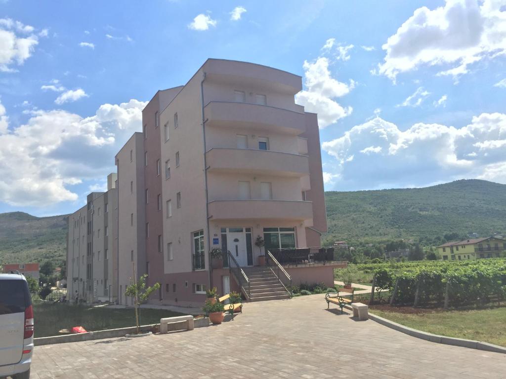 un gran edificio rosa con escaleras delante en Hotel Ivanković, en Međugorje