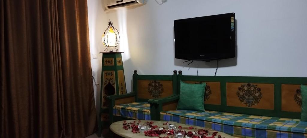 a living room with a couch and a flat screen tv at Maison Albatros in Mahdia