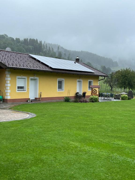 a yellow house with a large lawn in front of it at Ferienhaus mit Terrasse und viel Ruhe in Wieting