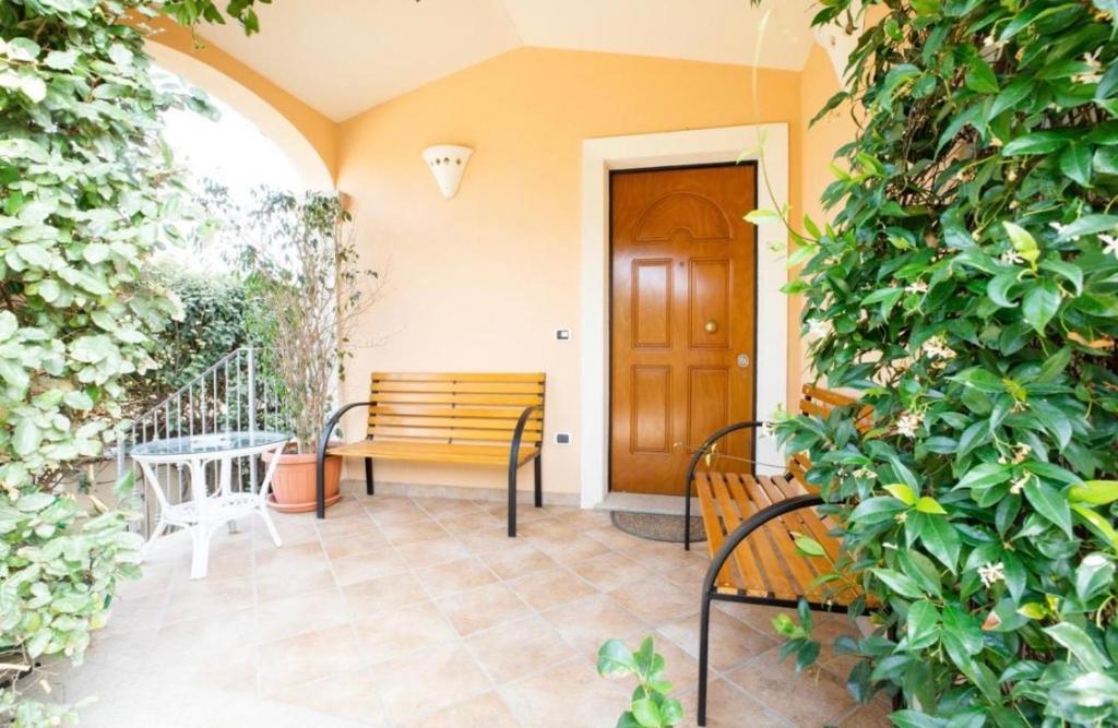 a porch with two benches and a wooden door at Sorin's house in Olbia
