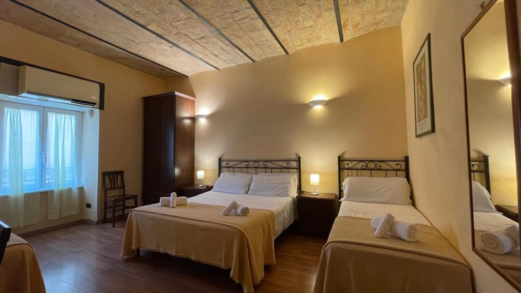 pokój hotelowy z 2 łóżkami i oknem w obiekcie Holiday Suite Roma w Rzymie