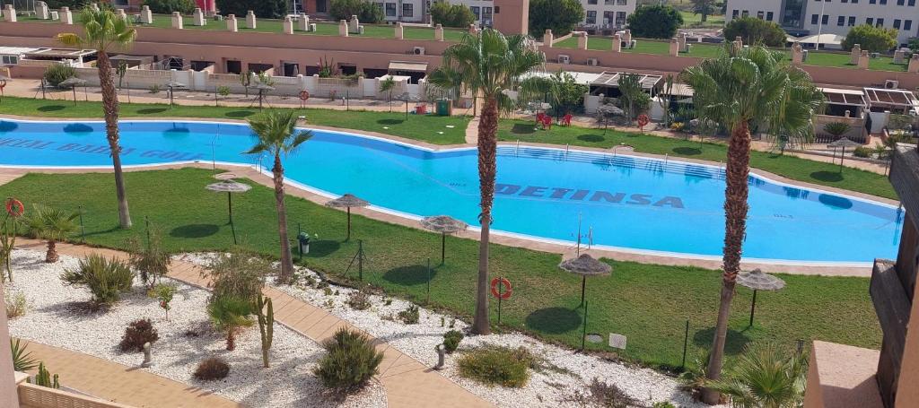 widok z góry na duży basen z palmami w obiekcie Ático de ensueño, El Toyo, Almería - Playas, Golf, Cabo de Gata w mieście Retamar