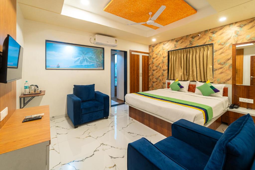 a hotel room with a bed and two chairs at Treebo Trend Kharadi Residency - Near EON IT Park in Pune