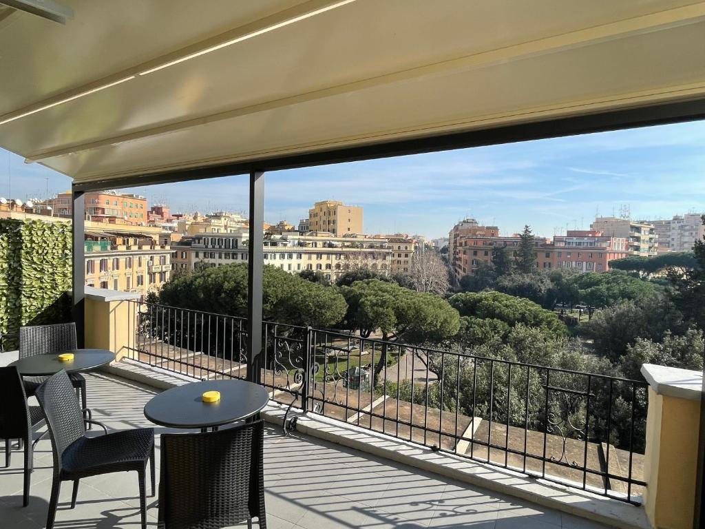 a balcony with tables and chairs and a view of the city at Re di Roma Rooftop in Rome
