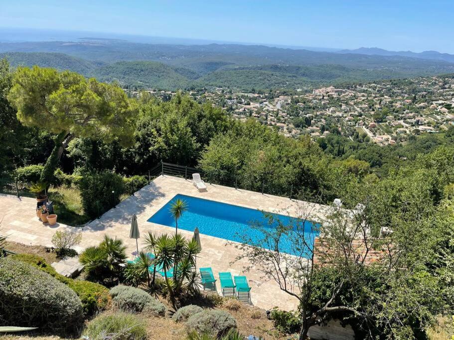 a swimming pool with chairs and a view of a city at Stunning Villa 5 bedroom Heaven on earth in Tourrettes-sur-Loup