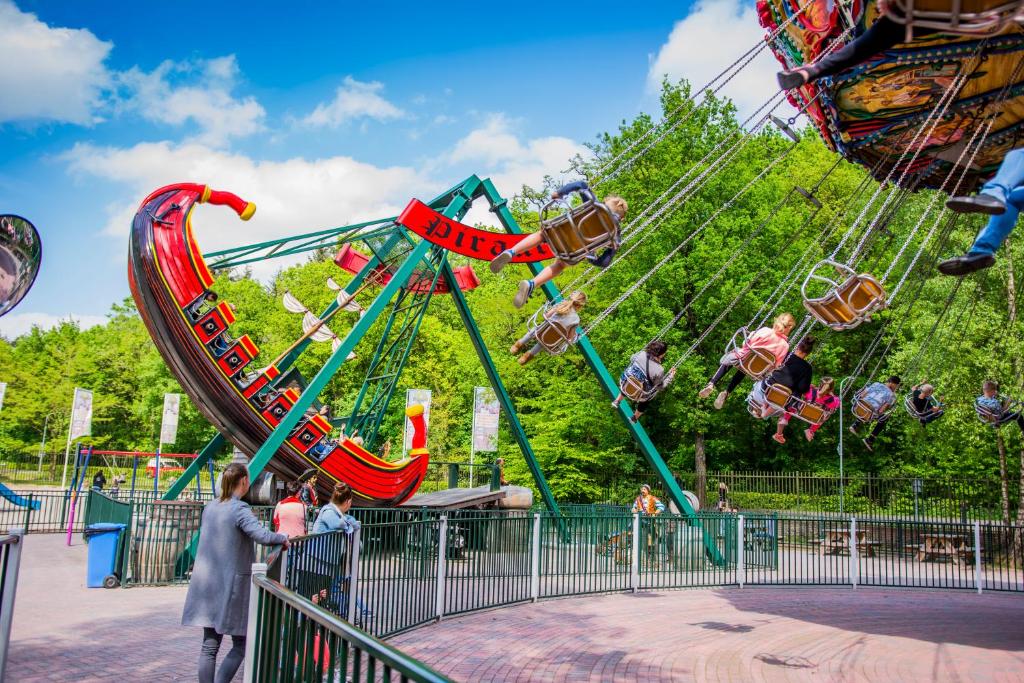 a carnival ride at a amusement park with a roller coaster at Glamping Drouwenerzand in Drouwen
