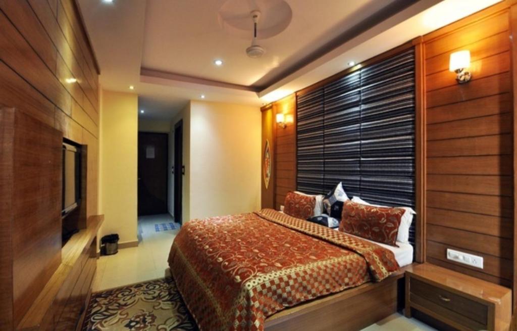 a bedroom with a bed and a wooden wall at Hotel Raj Mandir in Haridwār
