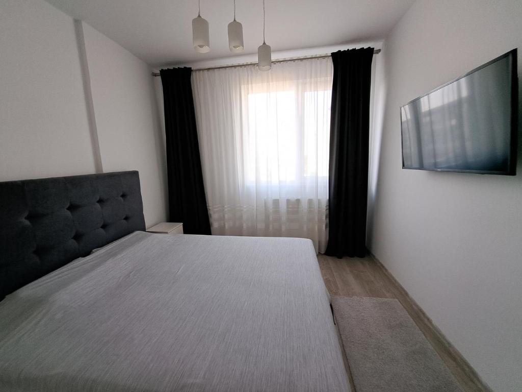 Popeşti-Leordeni的住宿－Siena Cozy retreat with self check in，一间卧室设有一张大床和一个窗户。