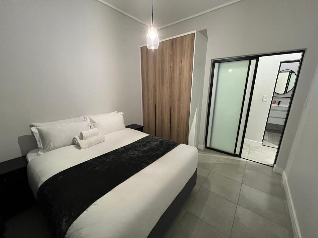 um quarto com uma cama grande e uma janela grande em Munyaka Lagoon Penthouse em Midrand