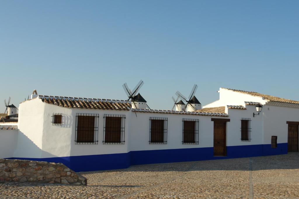 a white building with windmills on the roof at La Casa El Yelmo De Mambrino in Campo de Criptana