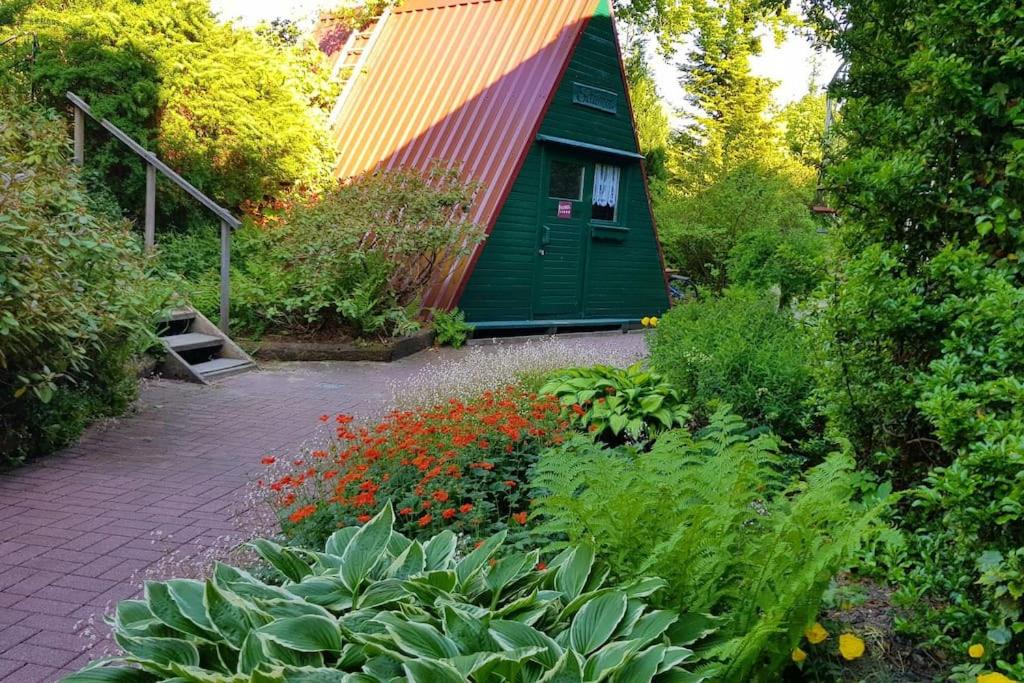 zieloną szopę z czerwonym dachem w ogrodzie w obiekcie Saunahotel mit Badezimmer w mieście Meinerzhagen