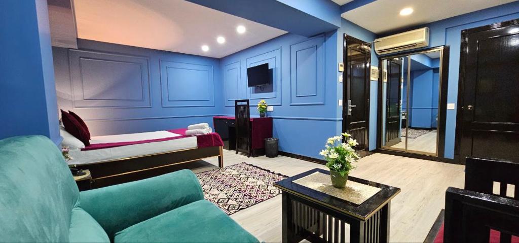 Haz Boutique Hotel Baku في باكو: غرفة زرقاء مع أريكة وسرير