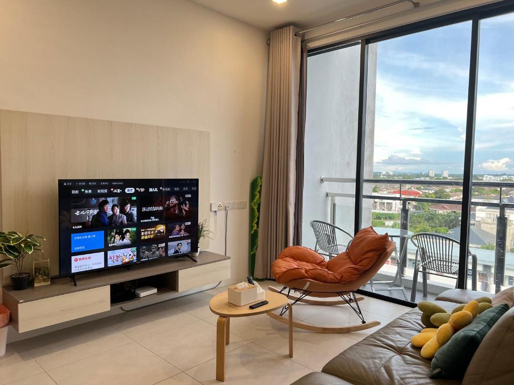 ein Wohnzimmer mit einem Flachbild-TV und einem Sofa in der Unterkunft LV Homestay @ Gala Residence in Kuching