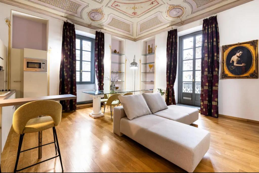uma sala de estar com um sofá e uma mesa em Dimora Novecento [PORTA NUOVA-CENTRO] em Turim