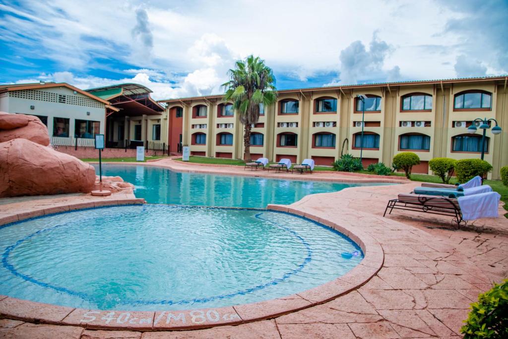 um grande edifício com uma piscina em frente a um edifício em M'kango Golfview Hotel em Lusaka