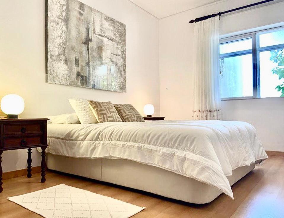 a white bedroom with a bed and a window at Charming 3 Bedroom Apartment in the centre of Faro in Faro