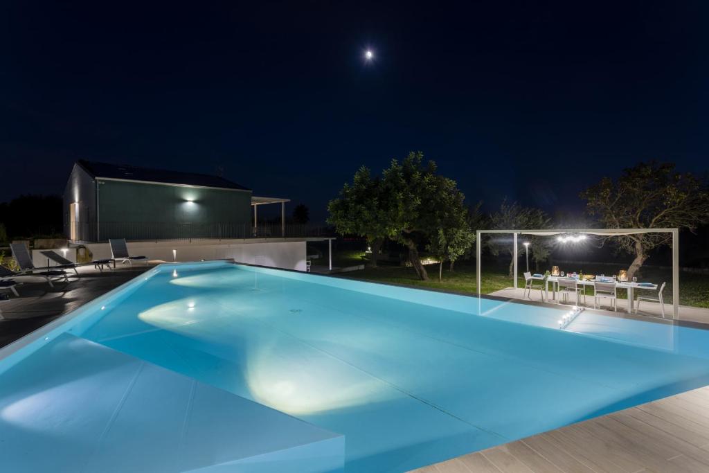 une piscine éclairée la nuit dans l'établissement Villa Iris - IsulaTravel, à Pozzallo