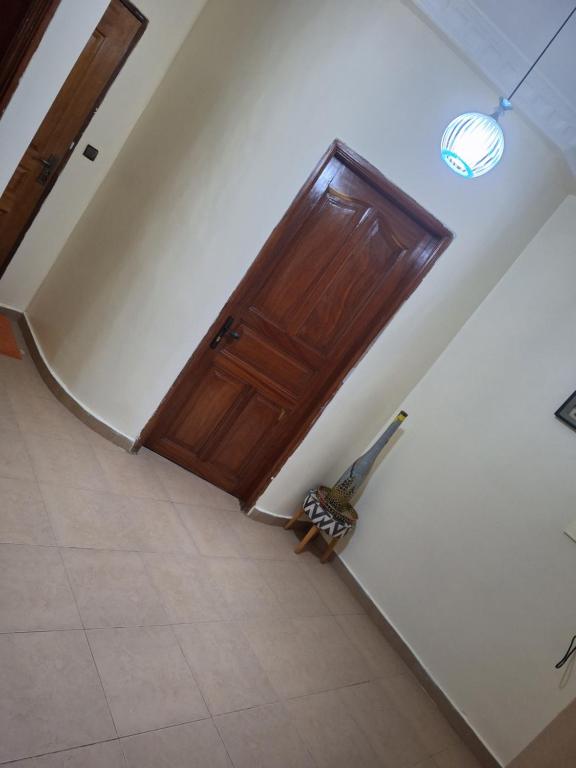 una habitación vacía con una puerta de madera en la pared en Studio spacieux, en Dakar