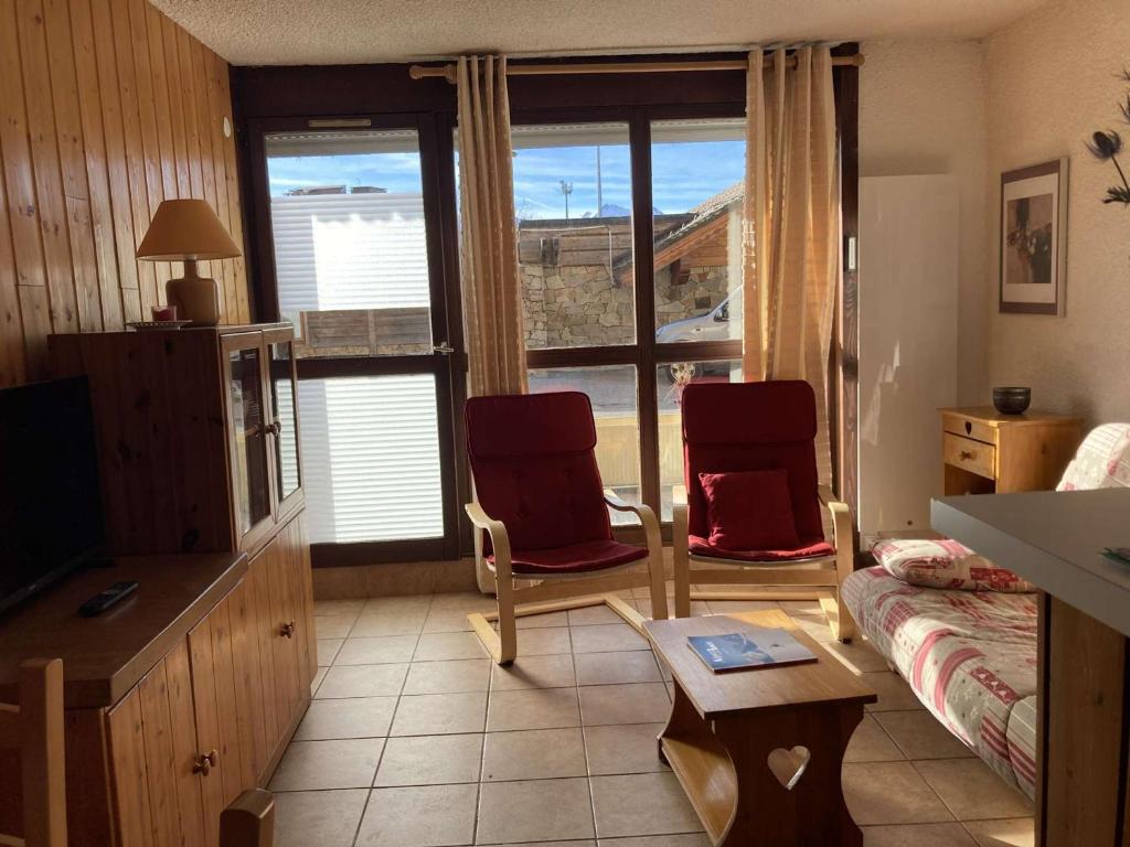 a living room with two red chairs and a couch at Appartement Huez, 1 pièce, 4 personnes - FR-1-405-11 in L'Alpe-d'Huez