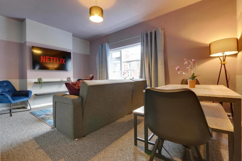 a living room with a couch and a table at Stylish 3 Bed Apartment, Abbeydale Rd - Sleeps 8, FREE Parking & Netflix in Sheffield