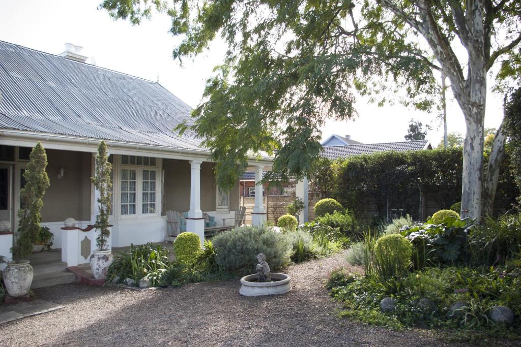 un jardín frente a una casa blanca en Tancredi B&B, en Pietermaritzburg