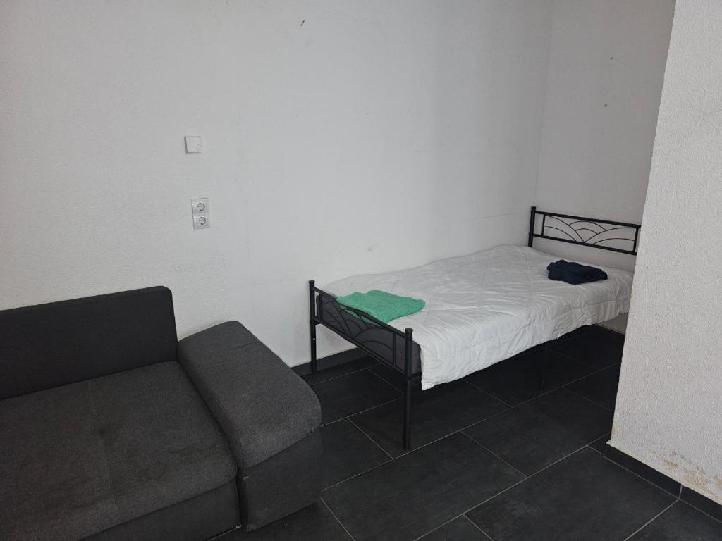 niewielka sypialnia z łóżkiem i kanapą w obiekcie Maria Zimmer im UG Neu und Modern w mieście Heilbronn