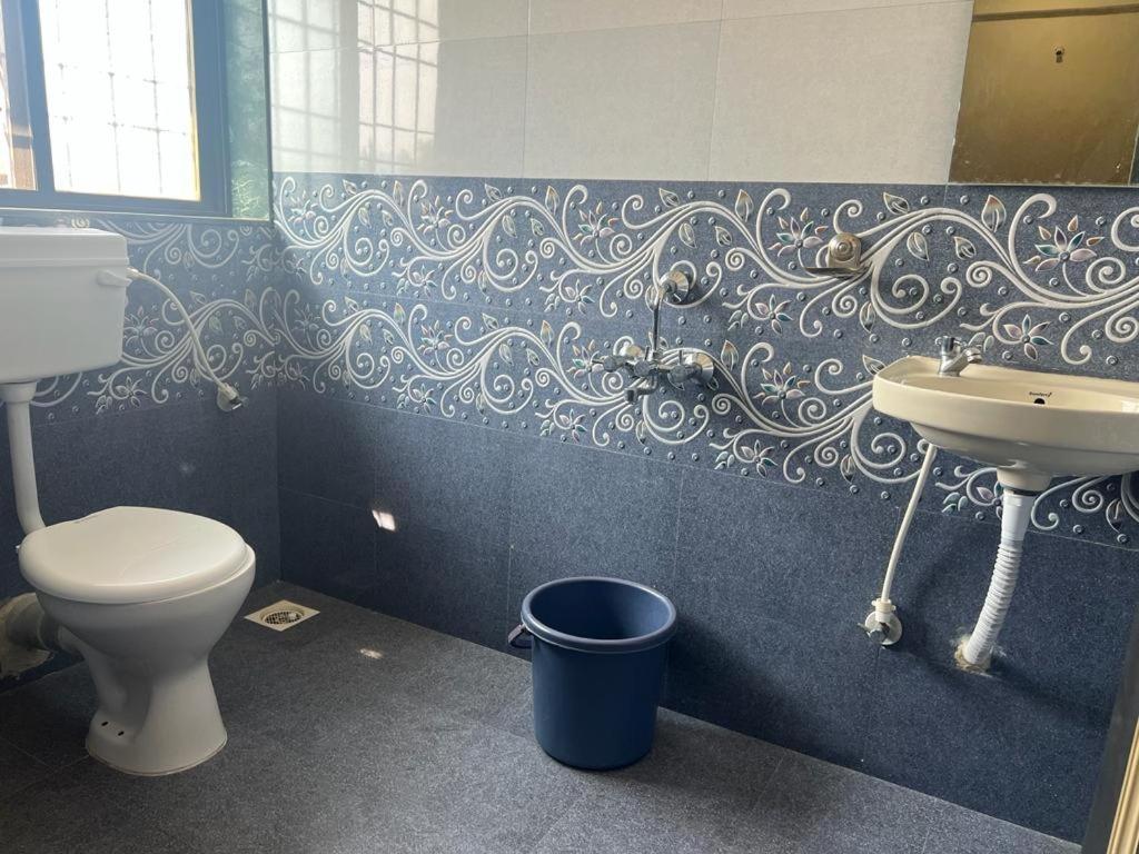 La salle de bains est pourvue de toilettes et d'un lavabo. dans l'établissement Blue Bell Homestay, à Lonavala