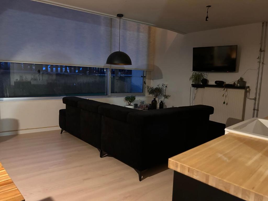 uma sala de estar com um sofá e uma grande janela em Homestay Properties em Amesterdão