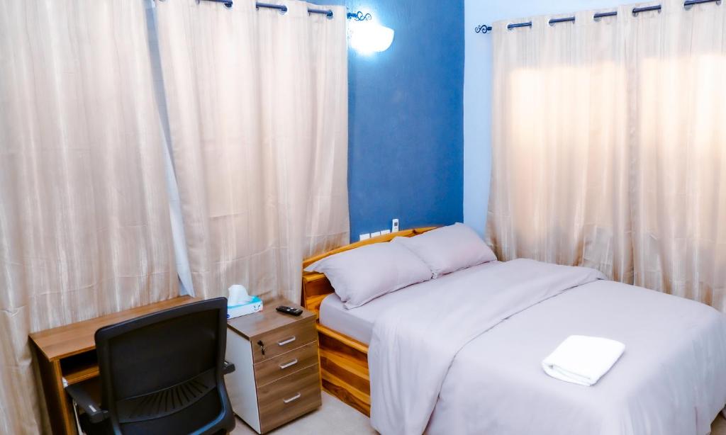 sypialnia z łóżkiem, biurkiem i krzesłem w obiekcie Studio cosy w mieście Lomé