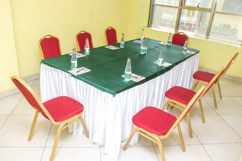 a table with red chairs and a green and white table at Tim Times Ltd self contained rooms in Nairobi