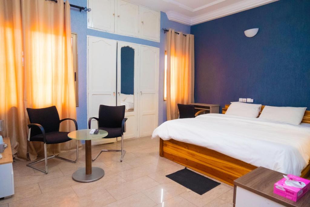 een slaapkamer met een bed en een tafel en stoelen bij Studio cosy et confortable in Lomé