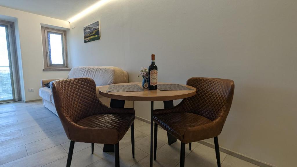 a table with a bottle of wine and two chairs at House of truelove/mountain pearl/45 to Verona in Bosco Chiesanuova