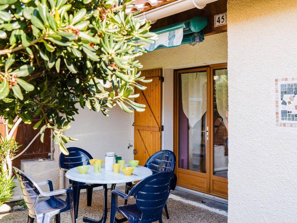 - une table blanche avec des chaises bleues et des boissons dans l'établissement Villa Studio Mezzanine à Narbonne-Plage - Terrasse Sud, Parking, 4 Couchages, Tout Confort - FR-1-409-103, à Narbonne-Plage
