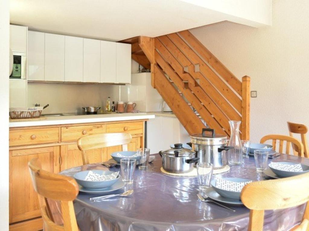 - une cuisine avec une table et de la vaisselle dans l'établissement Duplex 3 chambres au pied des pistes à Montgenèvre - FR-1-266-129, à Montgenèvre